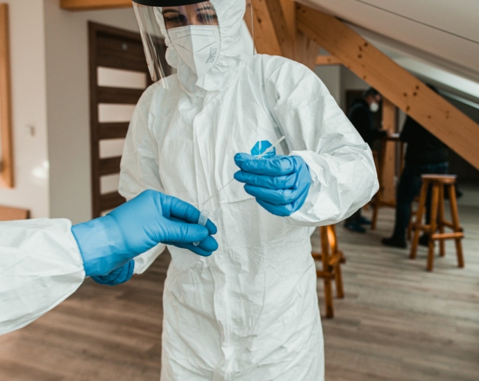 a person in a white suit and blue gloves