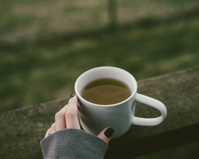 a woman's hand holding a cup of coffee