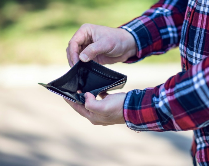 person in red blue and white plaid long sleeve shirt holding black leather bifold wallet