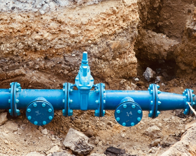 a blue pipe laying on top of a pile of dirt