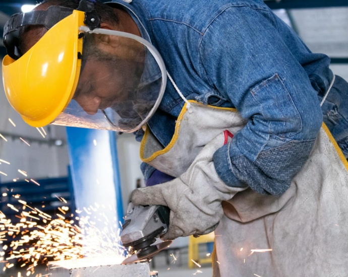 person in blue denim jeans and white and gray gloves holding yellow plastic bucket