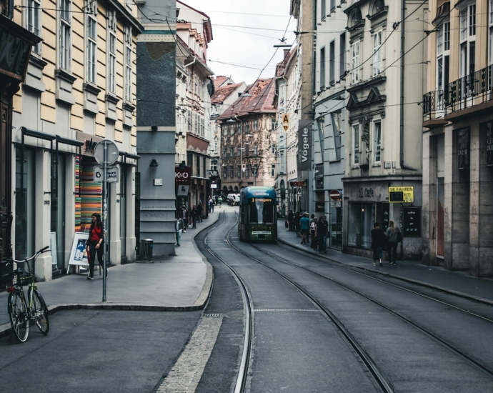 a narrow city street with a train on the tracks