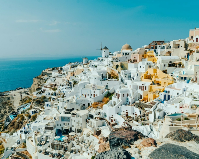 an aerial view of a village on a cliff overlooking the ocean