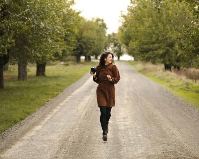 A woman is running down a dirt road