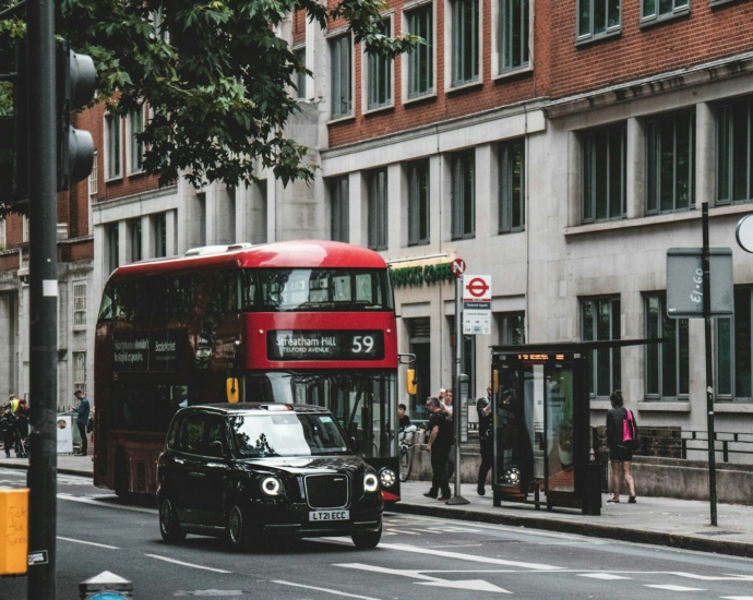 a black car and a red bus on a street