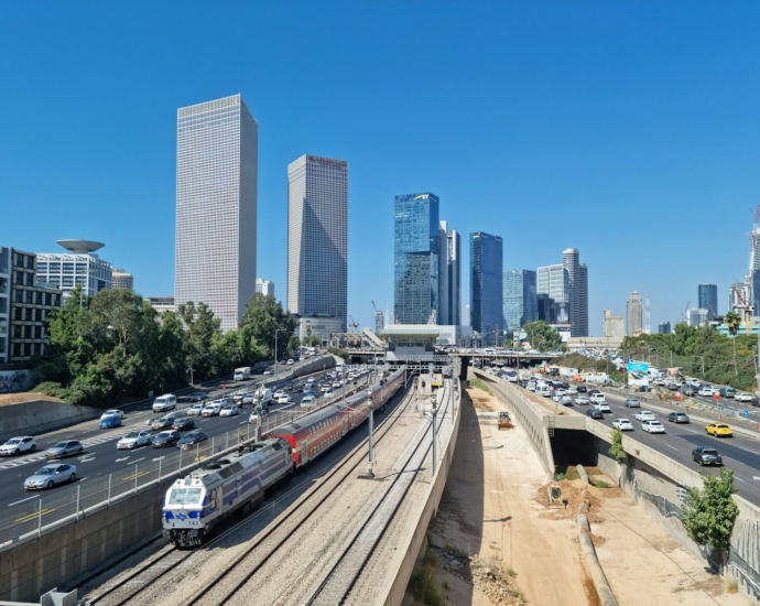 a train traveling through a city next to tall buildings