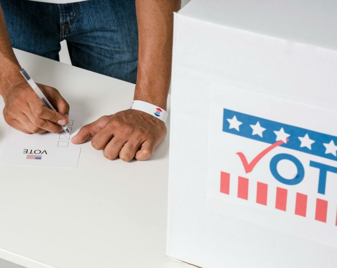 A Person with a Wristband Casting a Vote