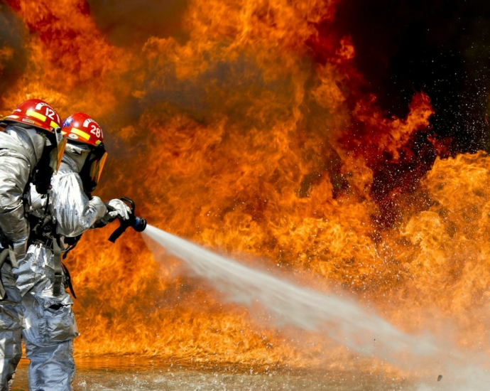 Brave firefighters in action extinguishing a large fire with determination and teamwork.