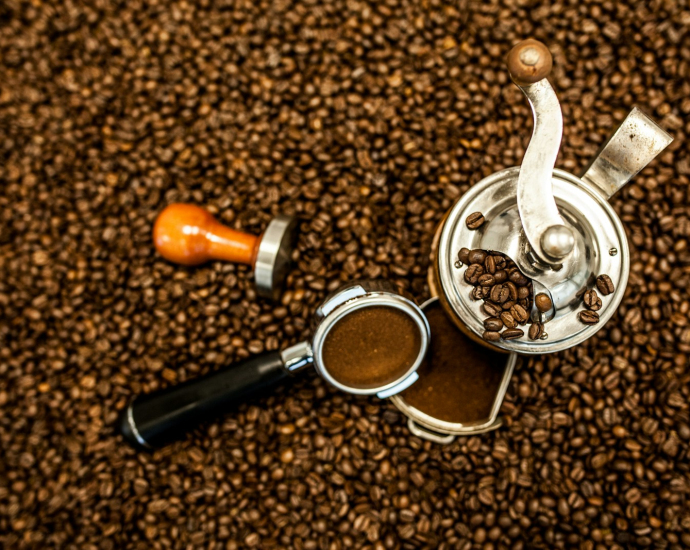 an overhead view of a coffee grinder and a cup of coffee