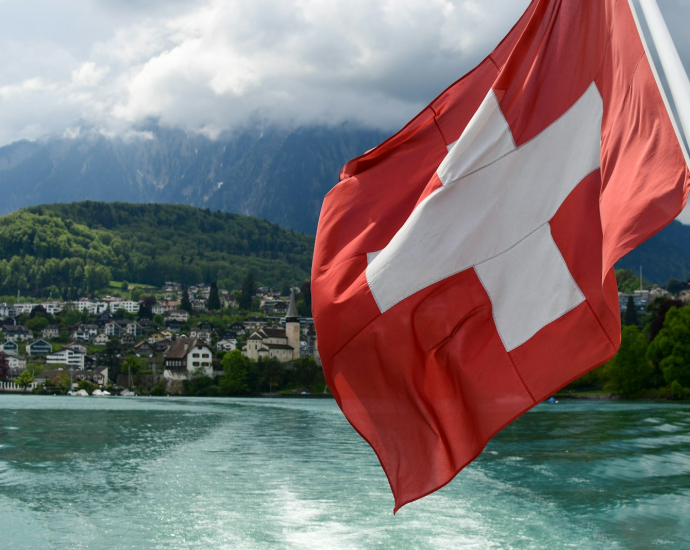 a red and white flag flying over a body of water