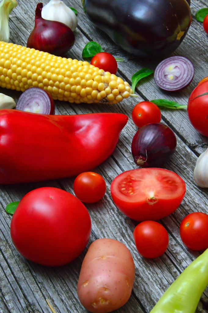 A vibrant assortment of fresh vegetables on a rustic wooden table, ready for cooking.