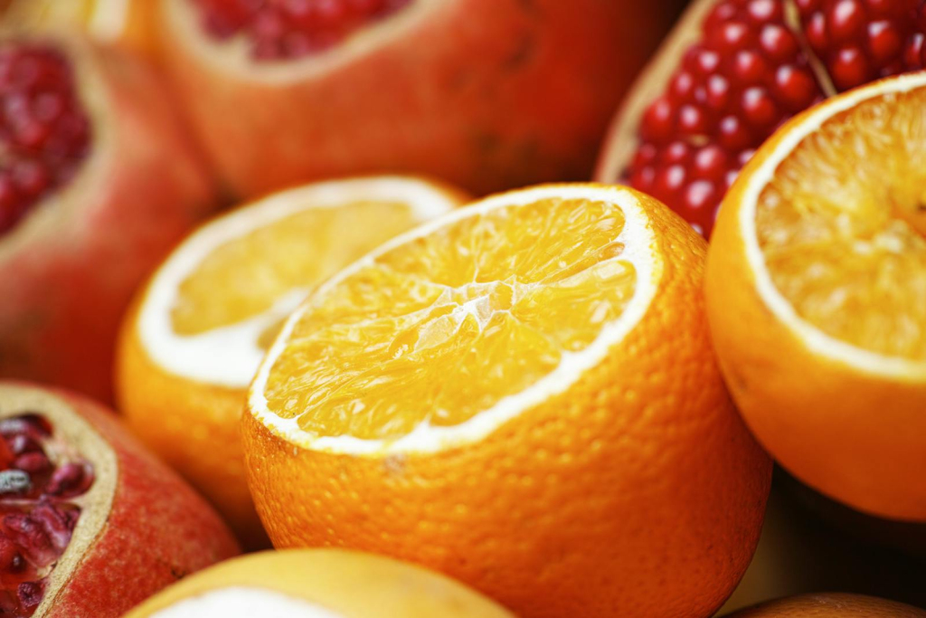 Close-up of sliced oranges and pomegranates showcasing vibrant, juicy freshness for a healthy breakfast.