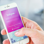 Close-up of a hand holding a smartphone displaying the Instagram login screen, highlighting mobile technology.