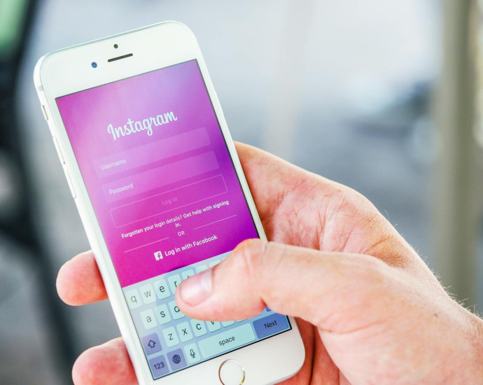 Close-up of a hand holding a smartphone displaying the Instagram login screen, highlighting mobile technology.