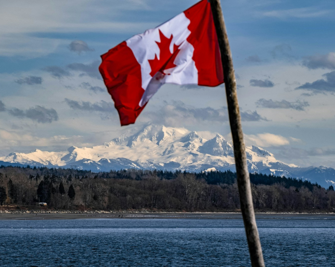 a canadian flag flying over a body of water