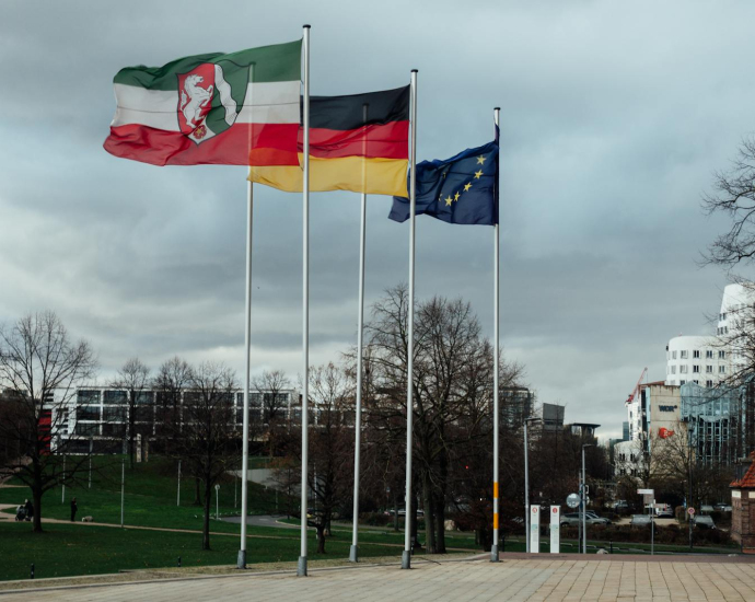 European and national flags in a Düsseldorf public space, showcasing modern architecture.