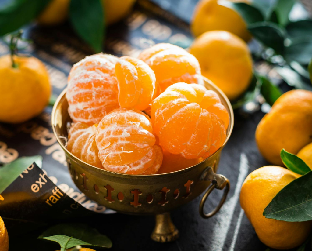 Vibrant peeled and whole tangerines in a rustic bowl highlighting freshness and health.