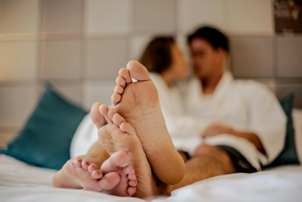 Blurred couple in bathrobes with focus on their feet, symbolizing relaxation and intimacy.