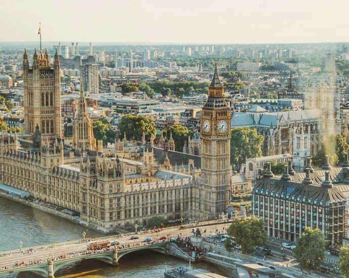 Stunning aerial view of London's iconic Big Ben and the river Thames under daylight.