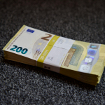 a stack of money sitting on top of a carpet