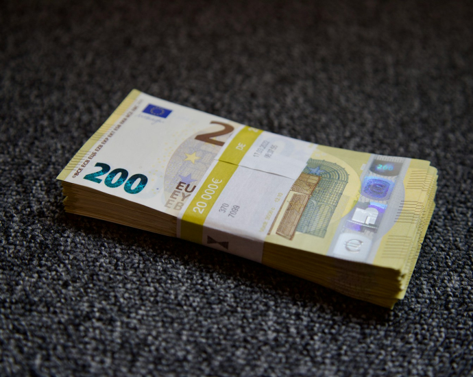 a stack of money sitting on top of a carpet