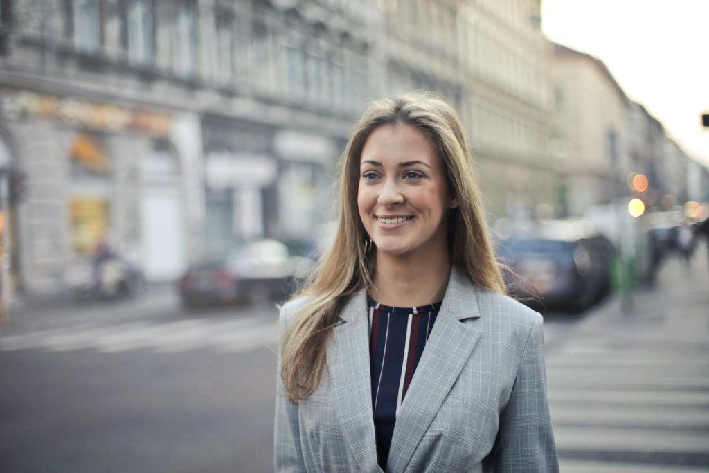 Confident businesswoman smiling outdoors in urban Budapest setting.