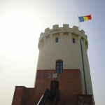 A tall tower with a flag on top of it