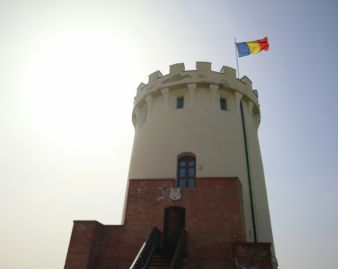 A tall tower with a flag on top of it