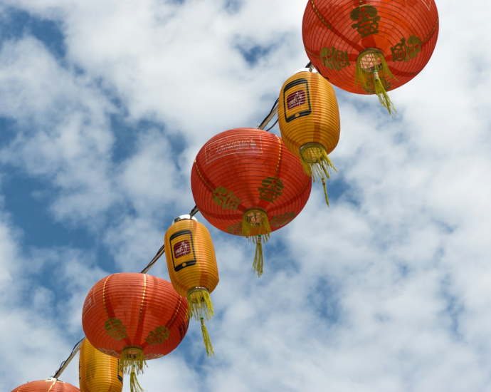 red and orange lantern lamp under white clouds and blue sky during daytime