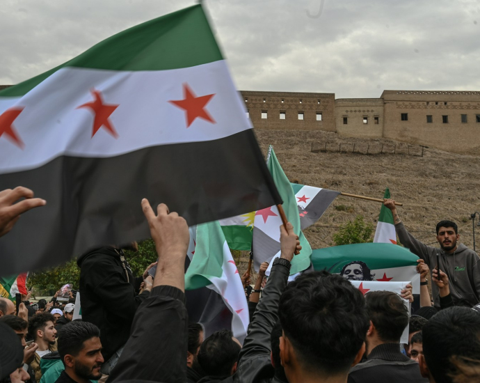 A group of people holding flags in front of a building