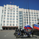 two motorcycles parked in front of a large building