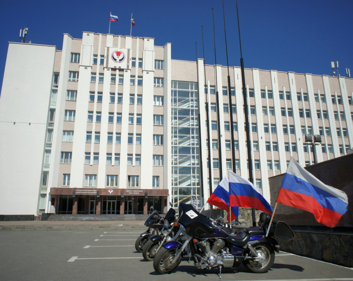 two motorcycles parked in front of a large building