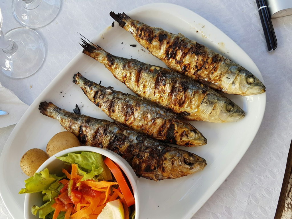 grilled fish with vegetable salad on white ceramic plate