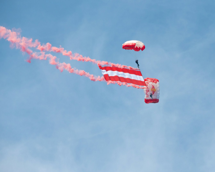 a person in the air with a parachute and a parachute