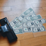 a pile of money sitting on top of a wooden floor