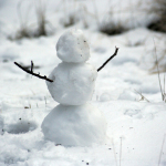 photo of snowman with stick hands on snow filed