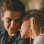 woman leaning on man's shoulder