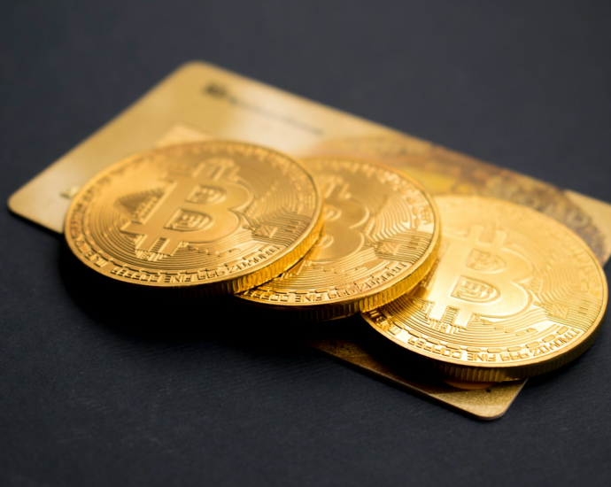 three round gold-colored Bitcoin tokens