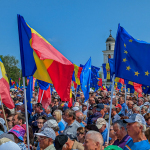 a large group of people holding flags in front of a building