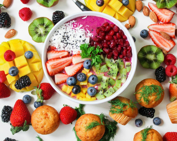 Vibrant smoothie bowl topped with assorted fresh fruits and muffins, perfect for a healthy snack.