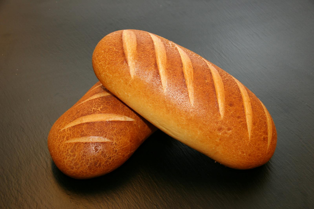 Close-up of two freshly baked loaves with crispy crust, ideal for food and still life photography.