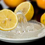 Close-up of fresh lemons on a glass juicer ready to make citrus refreshment.