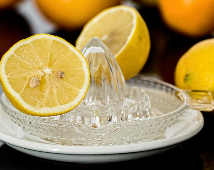 Close-up of fresh lemons on a glass juicer ready to make citrus refreshment.