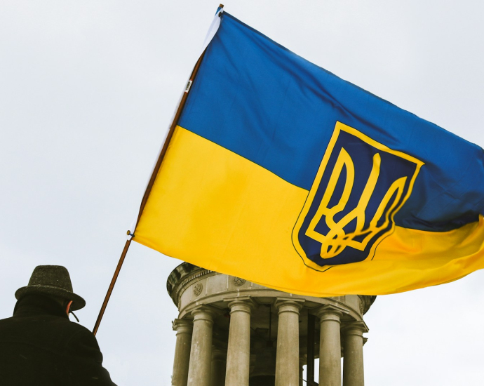 a man holding a flag in front of a building