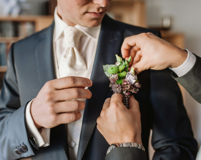 man in black suit holding bouquet of flowers