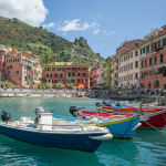 white and blue boat on water near buildings during daytime