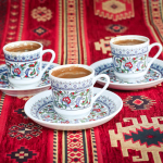 three multicolored floral ceramic cups and saucers