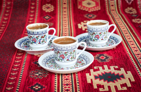 three multicolored floral ceramic cups and saucers