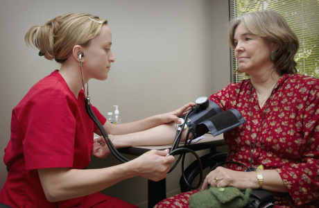 a woman with a stethoscope listening to a patient