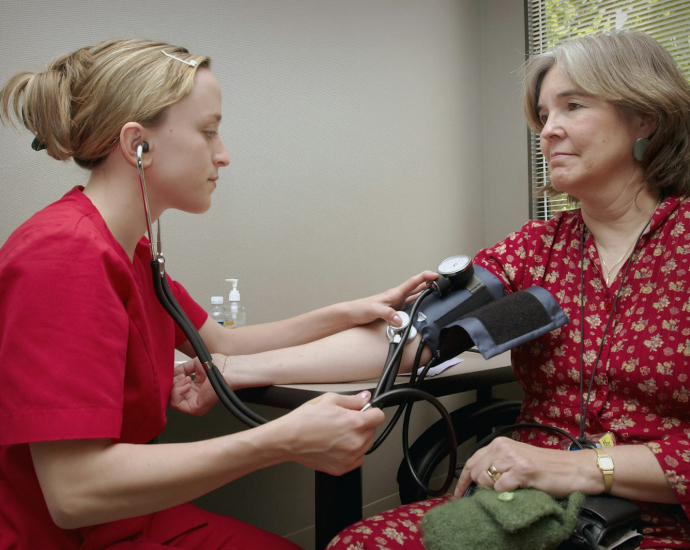 a woman with a stethoscope listening to a patient